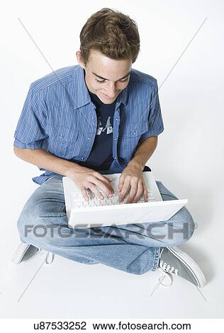 Stock Image - Teenage boy using laptop. Fotosearch