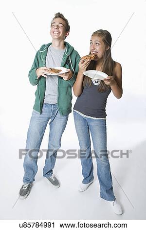 Stock Image - Teenage couple eating pizza. Fotosearch