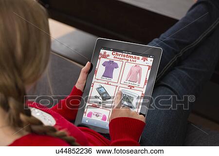 Teenage girl (14-15) sitting and using digital tablet for Christmas shopping View Large Photo Image Stock Photograph - Teenage girl (14-15) sitting and using digital tablet for Christmas shopping. Fotosearch