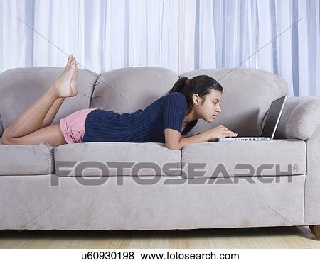 Teenage girl (14-15) using laptop on sofa View Large Photo Image Stock Photo - Teenage girl (14-15) using laptop on sofa. Fotosearch