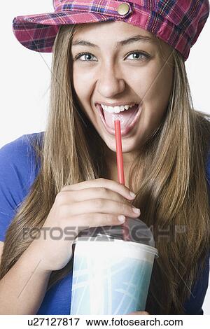 Stock Photo - Teenage girl drinking milkshake, portrait. Fotosearch