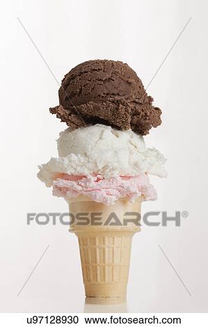 Stock Image - Three flavored ice creams stacked on cone. Fotosearch