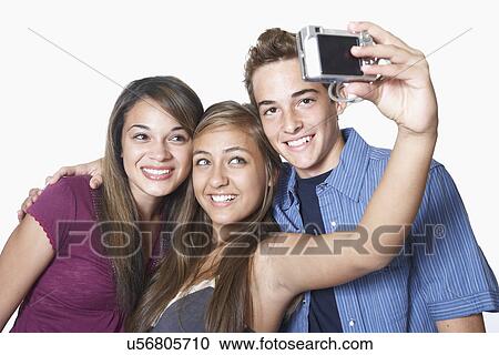 Three teenage friends photographing themselves View Large Photo Image Stock Image - Three teenage friends photographing themselves. Fotosearch