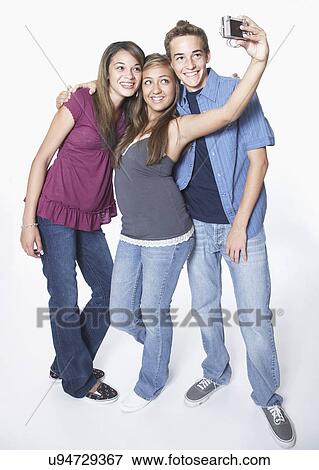 Stock Photo - Three teenage friends photographing themselves. Fotosearch