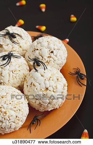 Stock Photo - Toy spiders crawling on popcorn balls. Fotosearch