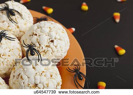 Stock Photo - Toy spiders crawling on popcorn balls. Fotosearch