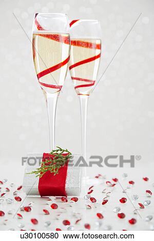 Stock Image - Two champagne flutes and gift. Fotosearch