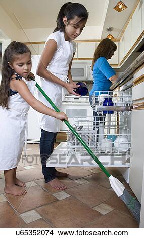 Two daughters (8-9, 14-15) helping mother in kitchen View Large Photo Image Picture - Two daughters (8-9, 14-15) helping mother in kitchen. Fotosearch