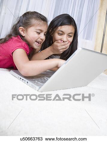 Two girls (8-9, 12-13) using laptop and laughing View Large Photo Image Stock Image - Two girls (8-9, 12-13) using laptop and laughing. Fotosearch