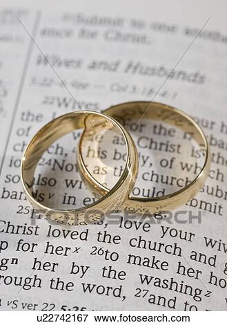 Stock Photo - Two wedding rings on vows. Fotosearch