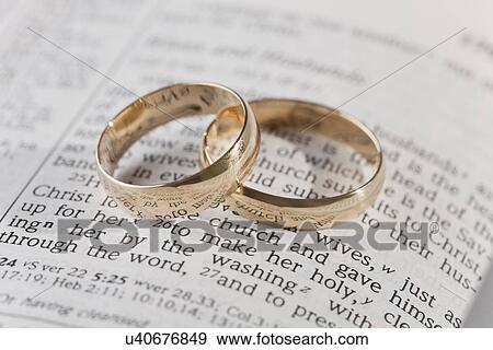Stock Photo - Two wedding rings on vows. Fotosearch