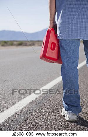 USA, Arizona, Man standing with canister looking on road View Large Photo Image Stock Image - USA, Arizona, Man standing with canister looking on road. Fotosearch