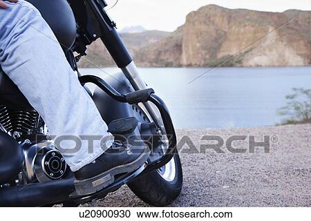 Stock Image - USA, Arizona, Phoenix, Biker on motorcycle in mountain area. Fotosearch