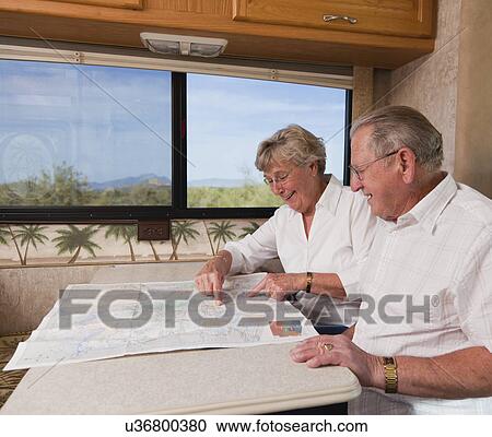 Stock Image - USA, Arizona, senior couple reading map. Fotosearch