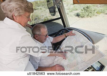Stock Image - USA, Arizona, senior couple reading map. Fotosearch