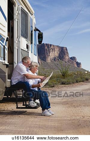 USA, Arizona, senior couple sitting in front of mobile home and reading map View Large Photo Image Picture - USA, Arizona, senior couple sitting in front of mobile home and reading map. Fotosearch
