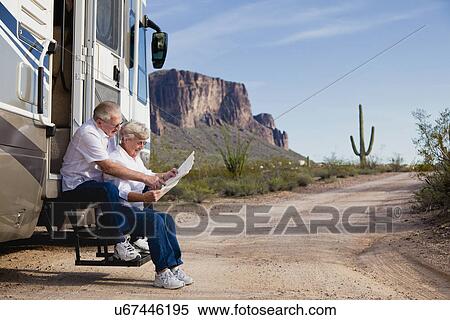 USA, Arizona, senior couple sitting in front of mobile home and reading map View Large Photo Image Stock Photography - USA, Arizona, senior couple sitting in front of mobile home and reading map. Fotosearch