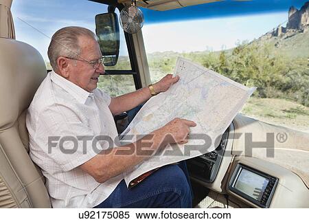 Stock Photography - USA, Arizona, senior man in car reading map. Fotosearch