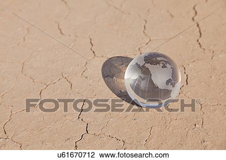 Stock Image - USA, Arizona, Small glass globe on desert. Fotosearch