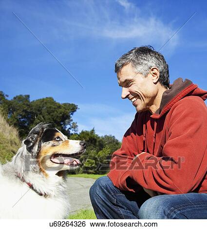 Stock Photograph - USA, California, Fairfax, Cheerful mature man with dog. Fotosearch