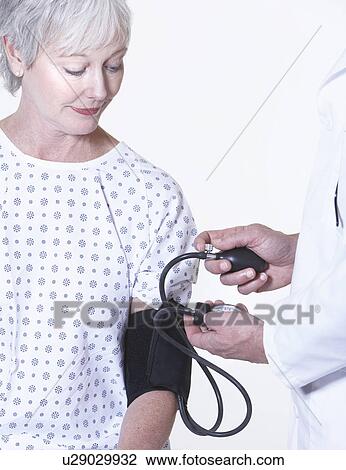 Stock Image - USA, California, Fairfax, Doctor checking female patient's blood pressure. Fotosearch