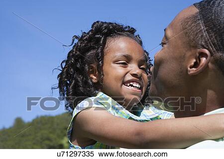 Stock Photography - USA California, Fairfax, father holding daughter (6-7) outdoors. Fotosearch