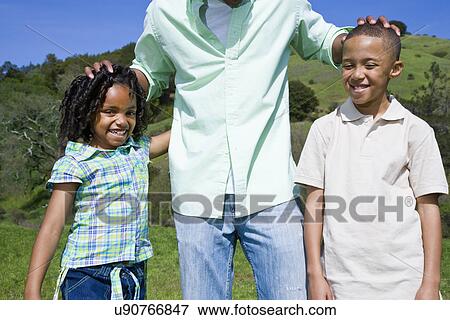 Stock Photo - USA California, Fairfax, father with two children (6-7, 8-9) outdoors. Fotosearch