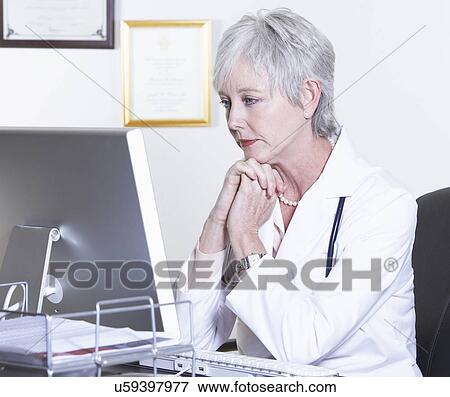 USA, California, Fairfax, Female doctor sitting in front of computer at desk View Large Photo Image Stock Photo - USA, California, Fairfax, Female doctor sitting in front of computer at desk. Fotosearch