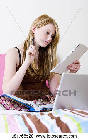 USA, California, Fairfax, girl (14-15) doing homework on bed View Large Photo Image Stock Photo - USA, California, Fairfax, girl (14-15) doing homework on bed. Fotosearch
