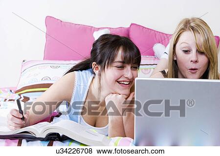 USA, California, Fairfax, girls (15-17) doing homework on bed View Large Photo Image Stock Photo - USA, California, Fairfax, girls (15-17) doing homework on bed. Fotosearch