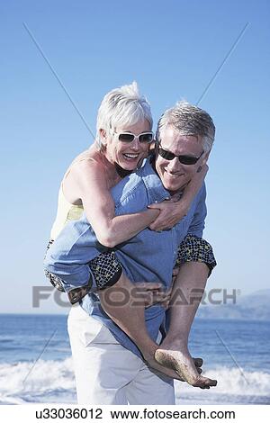 USA, California, Fairfax, Happy mature man giving piggy back ride to woman on beach View Large Photo Image Stock Image - USA, California, Fairfax, Happy mature man giving piggy back ride to woman on beach. Fotosearch