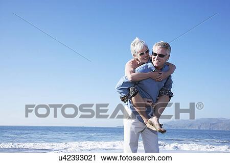USA, California, Fairfax, Happy mature man giving piggy back ride to woman on beach View Large Photo Image Stock Image - USA, California, Fairfax, Happy mature man giving piggy back ride to woman on beach. Fotosearch