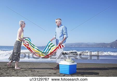 USA, California, Fairfax, Happy mature couple with blanket and cooler on beach View Large Photo Image Stock Photo - USA, California, Fairfax, Happy mature couple with blanket and cooler on beach. Fotosearch