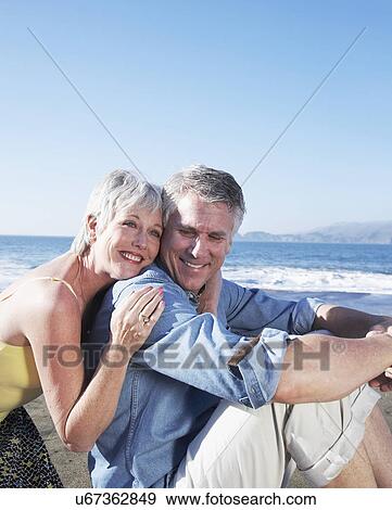 USA, California, Fairfax, Happy mature couple sitting on beach View Large Photo Image Stock Photo - USA, California, Fairfax, Happy mature couple sitting on beach. Fotosearch