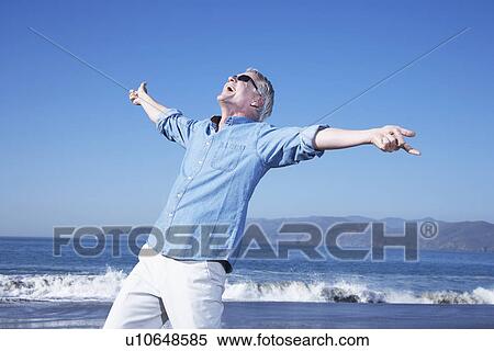 Stock Photography - USA, California, Fairfax, Happy mature man on beach. Fotosearch
