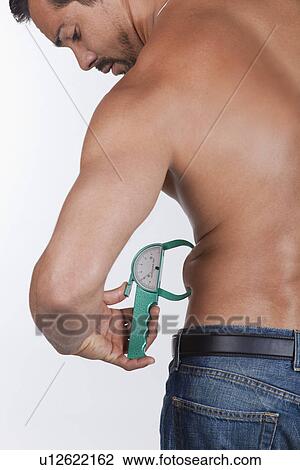 USA, California, Fairfax, Man measuring belly with caliper View Large Photo Image Stock Image - USA, California, Fairfax, Man measuring belly with caliper. Fotosearch