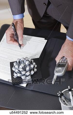 USA California, Fairfax, man signing document on desk with gift View Large Photo Image Stock Image - USA California, Fairfax, man signing document on desk with gift. Fotosearch