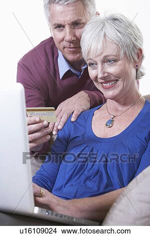 Picture - USA, California, Fairfax, Mature couple on line shopping. Fotosearch