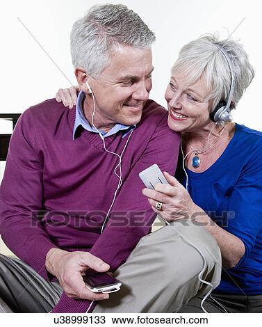 Stock Image - USA, California, Fairfax, Mature couple listening music together. Fotosearch