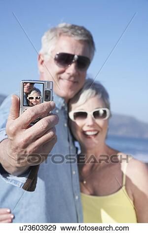 USA, California, Fairfax, Mature couple photographing self against blue sky View Large Photo Image Stock Photo - USA, California, Fairfax, Mature couple photographing self against blue sky. Fotosearch