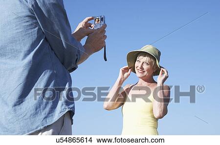 USA, California, Fairfax, Mature man photographing woman against blue sky View Large Photo Image Picture - USA, California, Fairfax, Mature man photographing woman against blue sky. Fotosearch