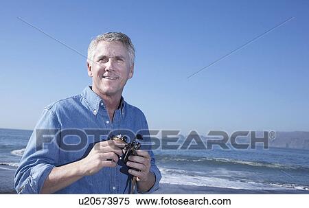 USA, California, Fairfax, Mature man with binoculars on beach View Large Photo Image Stock Photography - USA, California, Fairfax, Mature man with binoculars on beach. Fotosearch
