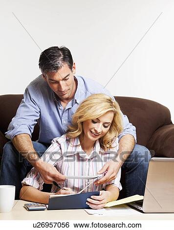 Stock Photograph - USA, California, Fairfax, Mid adult couple paying bills. Fotosearch