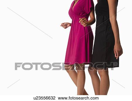 Stock Image - USA, California, Fairfax, Midsection of two women against white background. Fotosearch