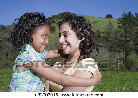Stock Photography - USA California, Fairfax, mother holding daughter (6-7) outdoors. Fotosearch