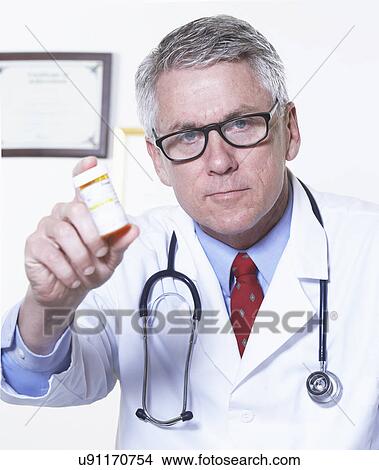 USA, California, Fairfax, Portrait of male doctor holding pill bottle View Large Photo Image Picture - USA, California, Fairfax, Portrait of male doctor holding pill bottle. Fotosearch