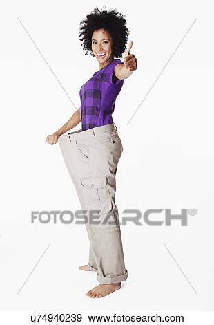 Stock Photo - USA, California, Fairfax, Portrait of young woman with loose pants. Fotosearch