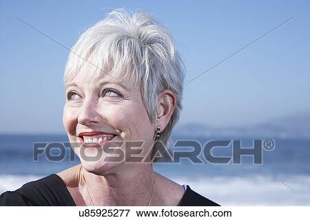 Stock Photo - USA, California, Fairfax, Portrait of smiling woman on beach. Fotosearch
