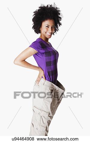 Stock Photo - USA, California, Fairfax, Portrait of young woman with loose pants. Fotosearch