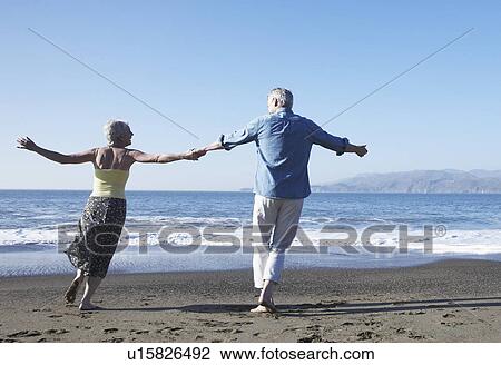 USA, California, Fairfax, Rear view of happy mature couple dancing on beach View Large Photo Image Stock Image - USA, California, Fairfax, Rear view of happy mature couple dancing on beach. Fotosearch